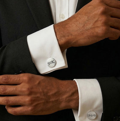 Close-up of a person wearing black suit with white dress shirt and cufflinks.